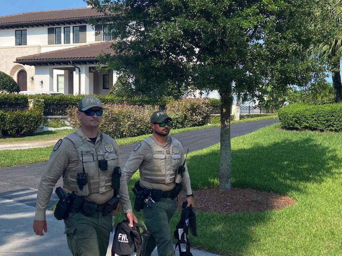 Agentes de la Comisión de Conservación de Pesca y Vida Silvestre de la Florida (FWC) saliendo de la propiedad en donde la policía dijo que se encontraba un barco que coincidía con la descripción del que golpeó y mató a Ella Adler cerca de Nixon Beach Sandbar.