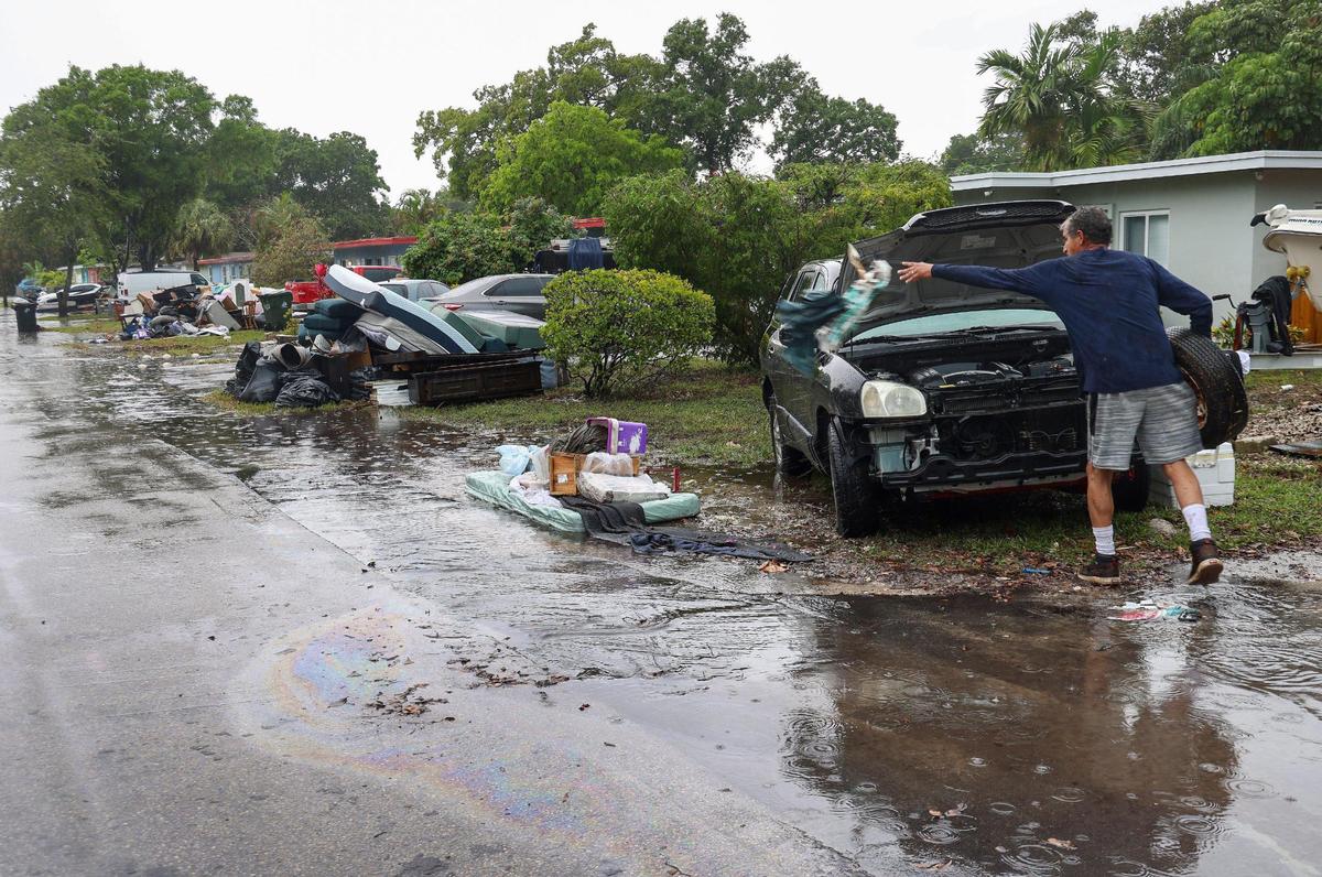As the rain returns, resident Paul Guerrero continues the clean-out process at his home as discarded water-damaged items pile up on the neighborhood’s street on Monday, April 17, 2023.