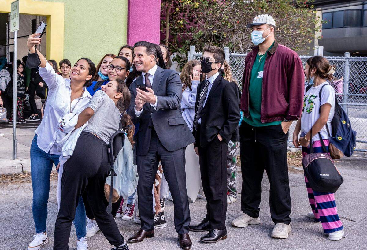  Miami-Dade Public Schools Superintendent Alberto Carvalho poses for a selfie with students from iPrep Academy in Miami and Miami Dolphins player Brennan Scarlett at dismissal time on Dec. 17, 2021. Miami Dade School Board Chair Perla Taberes Hantman said Wednesday that Carvalho's last day will be Feb. 3.