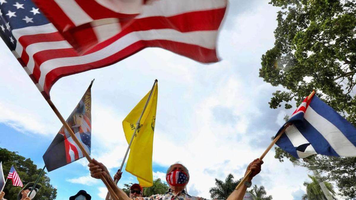 Silvio Rodriguez holds an American and Cuban flag at a rally for Donald Trump in Miami Lakes on June 14, 2020. 