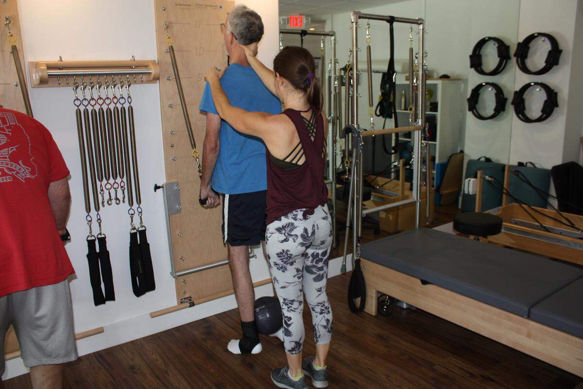 Kelsey Garcia, a doctor of physical therapy and certified Pilates instructor, works with Mark Worsdale, 64, in her “Pilates for Neurological Conditions” class at the South Miami studio of Pilates In The Grove. Worsdale has Parkinson’s disease. The next session starts Oct. 1.
