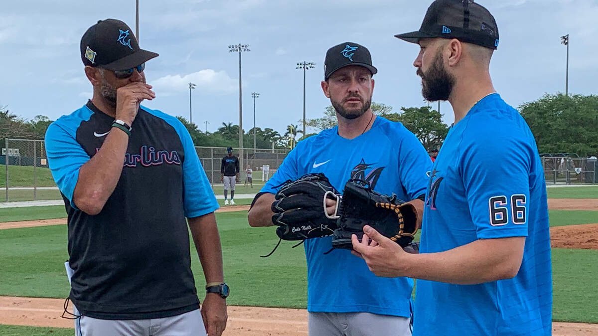 Miami Marlins pitchers Cole Sulser (center) and Tanner Scott (right) talk with bullpen coach Wellington Cepeda (left) during a workout on Monday, April 4, 2022, on the back fields of the Roger Dean Chevrolet Stadium complex in Jupiter, Florida.