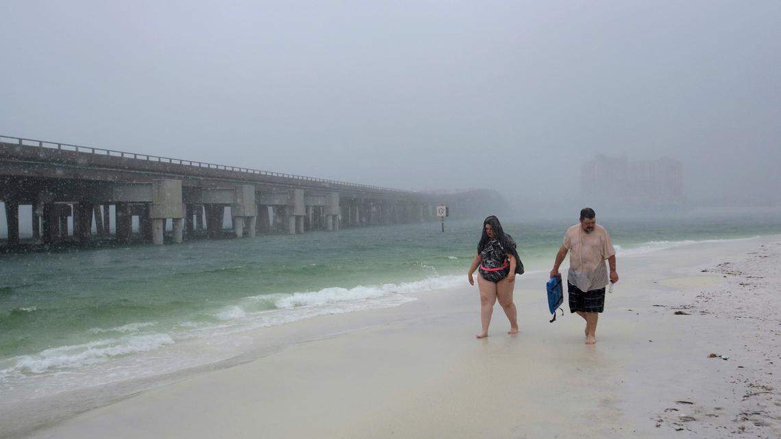 Emily Muller, left, and her father, Bob, walk through the rain as Subtropical Storm Alberto makes landfall on Monday, May 28, 2018, in Destin, Fla.