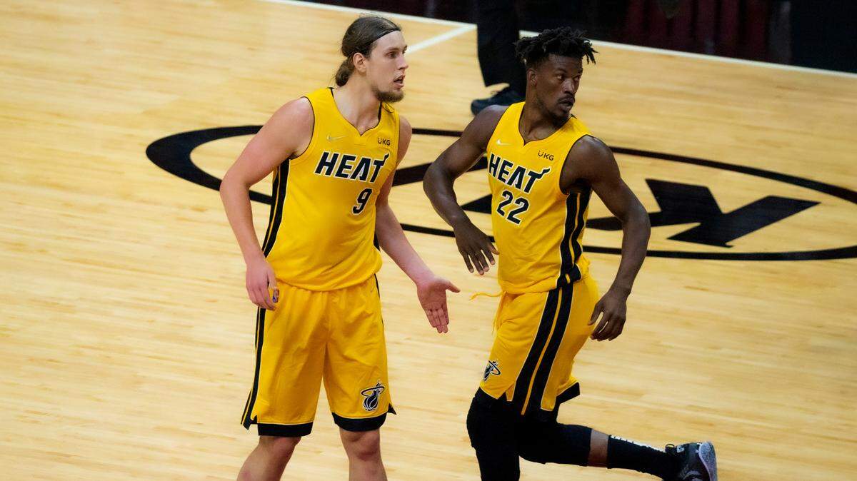 El pívot del Miami Heat, Kelly Olynyk (9), es felicitado por su compañero de equipo, el alero del Heat, Jimmy Butler (22), luego de anotar contra el Orlando Magic en el primer cuarto de su partido de baloncesto de la NBA en el AmericanAirlines Arena el jueves 11 de marzo de 2021.