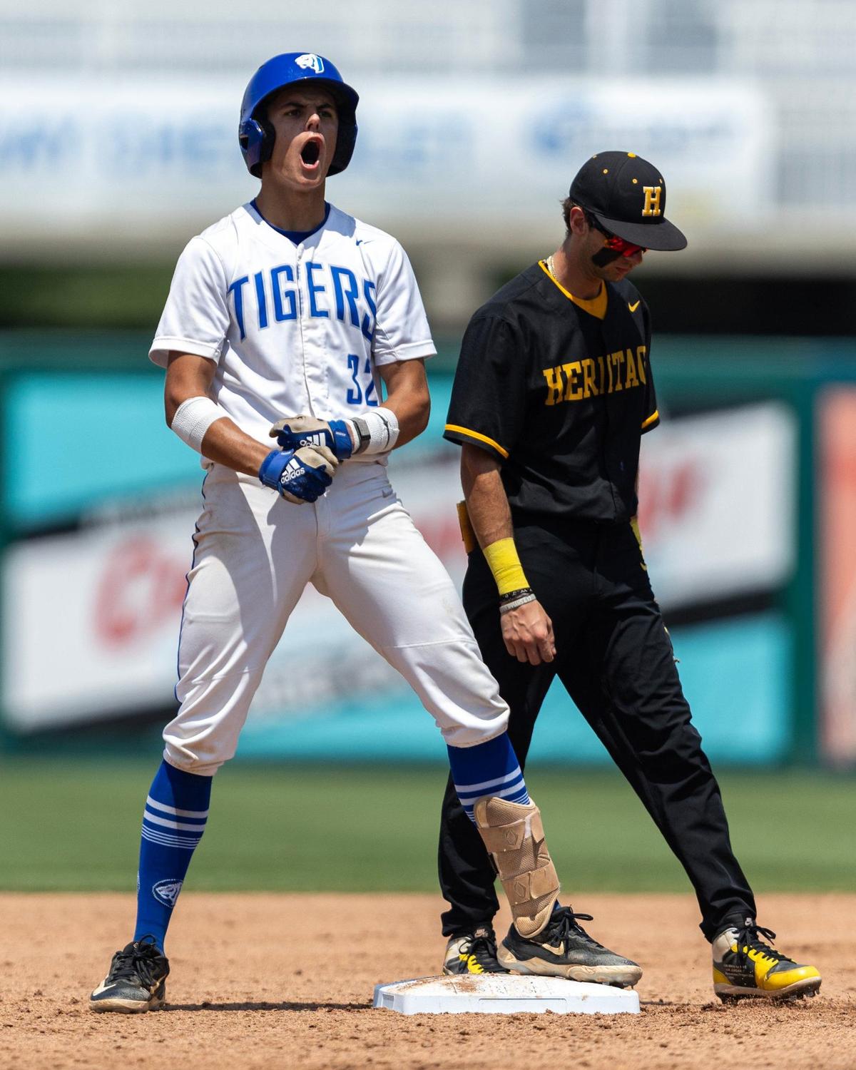 Jesuit Tigers base runner Kaden Waechter (32) reacts to getting on base as American Heritage second baseman Chris Levy looks on during the Class 5A state baseball championship game at Hammond Stadium on Saturday, May 18, 2024, in Fort Myers, Fla.