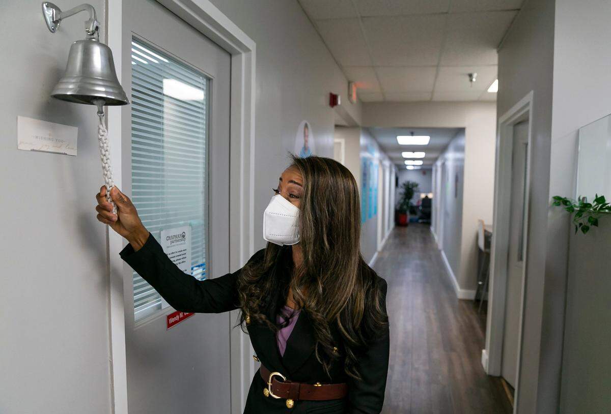 Symeria Hudson, the president and CEO of Chapman Partnership, rings a bell after the nonprofit received a $25,000 donation from Florida East Coast Industries.