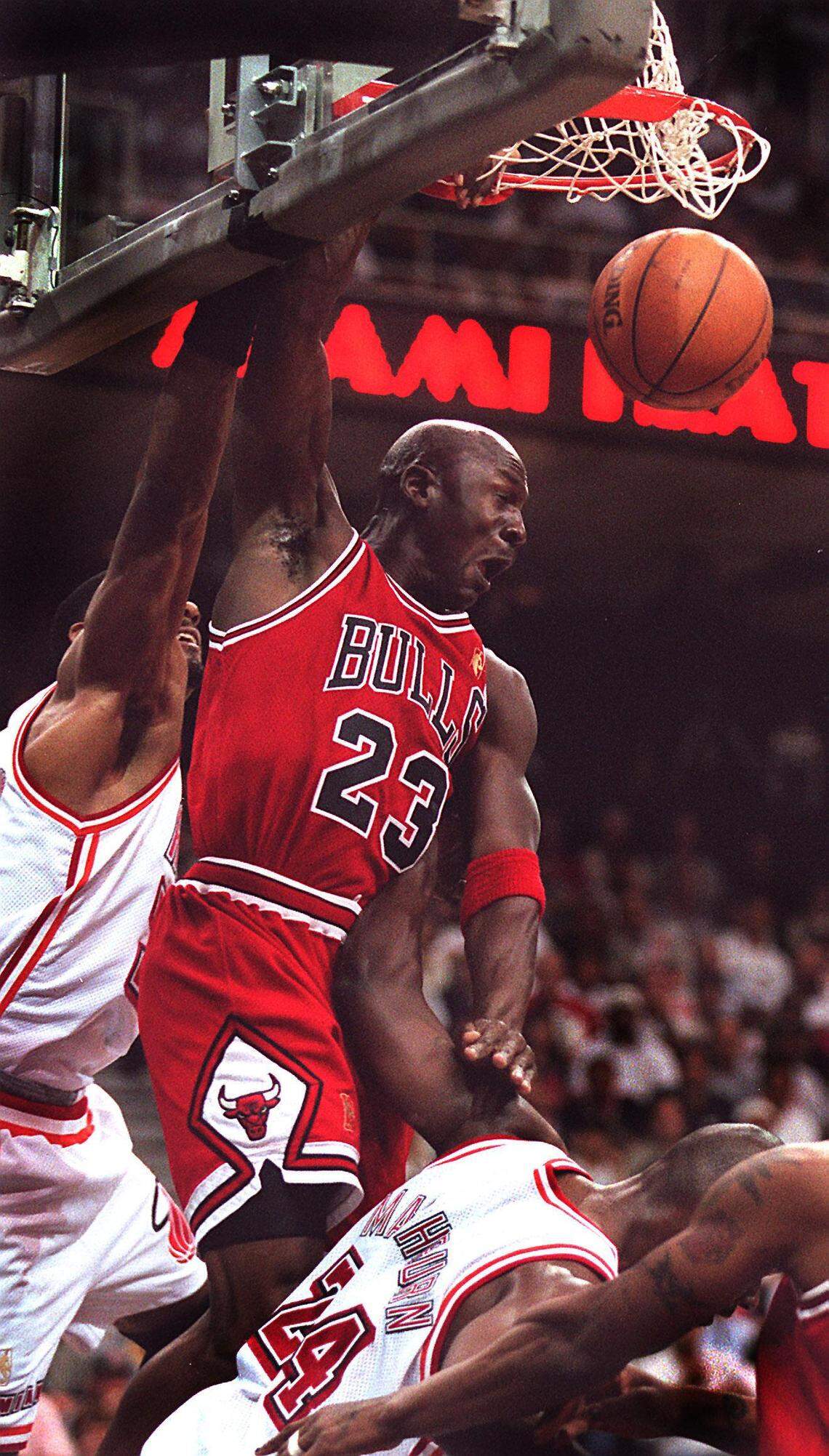 FILE PHOTO - Michael Jordan dunks over the Heat’s Alonzo Mourning and Jamal Mashburn, to set the earlytone of the the game. The Bulls go up three -zero over the Heat in the Eastern Conference Finals. This was not the game where the undermanned Heat squad beat the Bulls.
