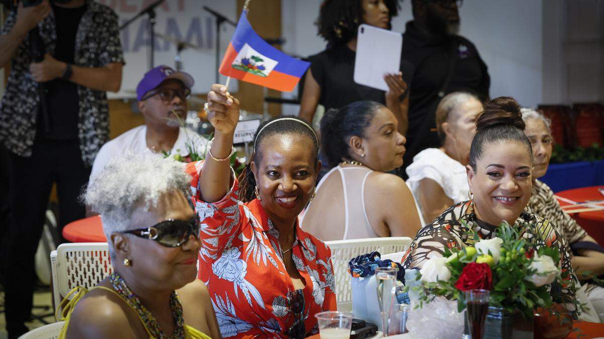 Micaelle Elicier waves a Haitian flag as ARTBEAT MIAMI honors Haiti's 1974 World Cup team players at the Little Haiti Cultural Center in Miami, Florida, on Sunday, May 24, 2026.