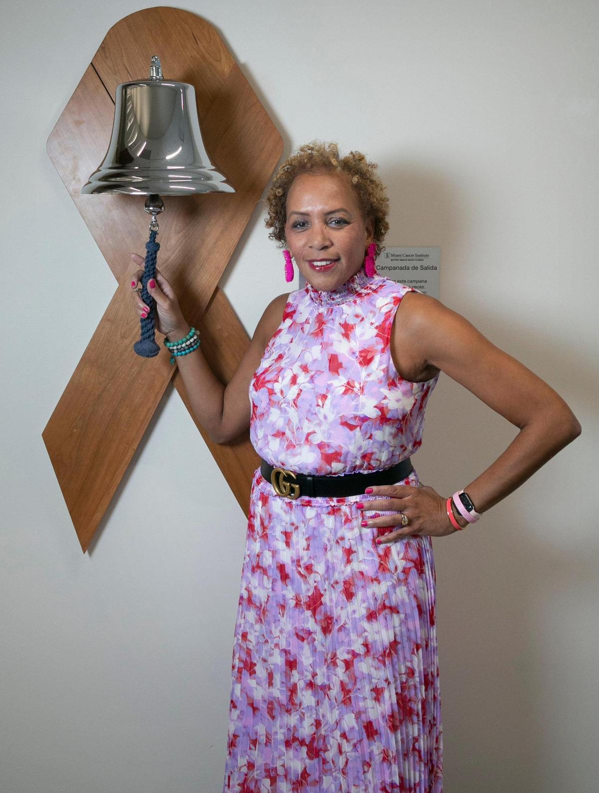 Angela Taylor stands at the bell she rang after her last treatment for breast cancer at Baptist Health’s Miami Cancer Institute Plantation location on Oct. 8, 2021. Taylor is a breast cancer survivor and a patient of Dr. Lauren Carcas. 