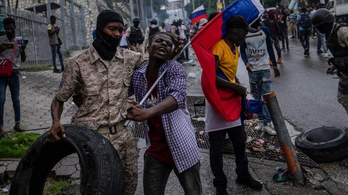 Police move demonstrators from in front of the Canadian Embassy during a protest to reject an international military force requested by the government in Port-au-Prince, Haiti, Monday, Oct. 24, 2022.