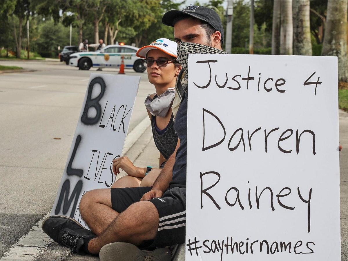 Black Lives Matter protesters sit on the curb as organizers make speeches. Trump supporters and Black Live Matter protesters intersect at a distance as both groups engaged at 7900 block of NW 154th Street in Miami Lakes, Florida on Sunday, June 28, 2020.