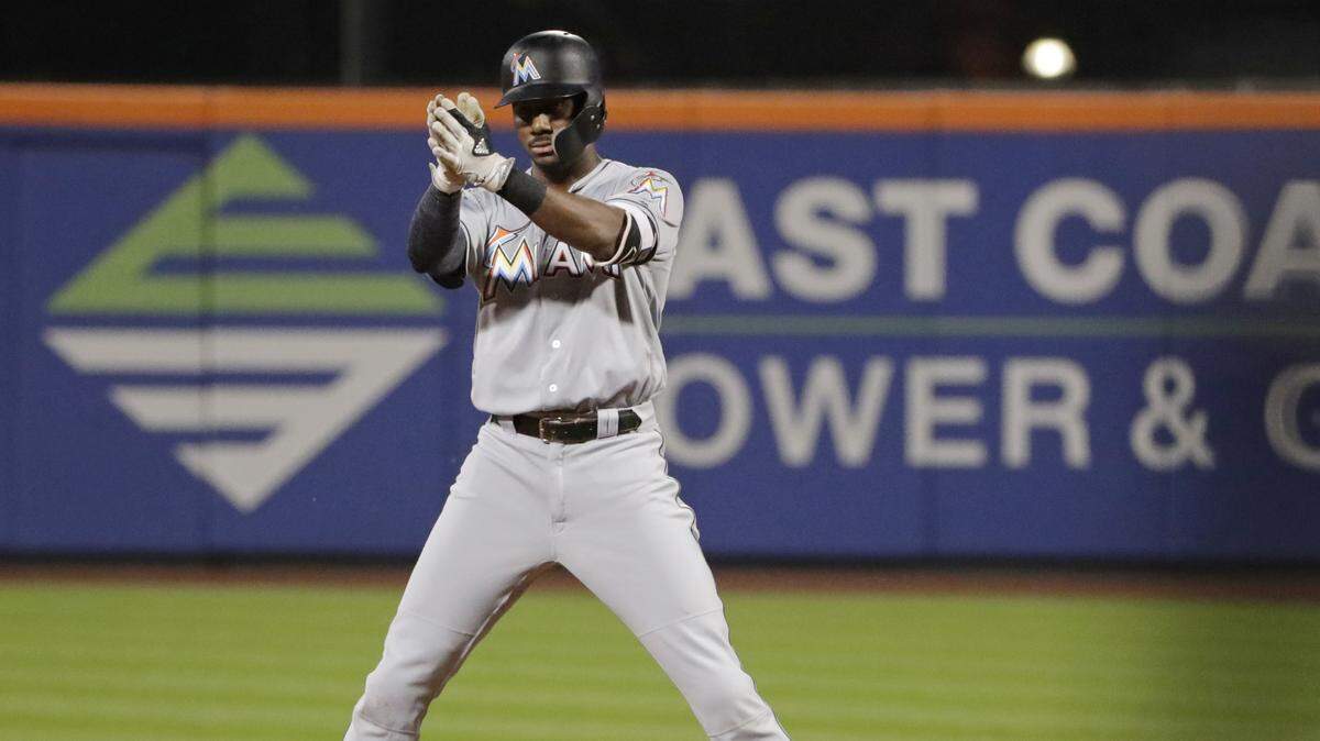 Miami Marlins’ Lewis Brinson gestures to his teammates after hitting a two-run double during the fourth inning of a baseball game against the New York Mets, Tuesday, Sept. 11, 2018, in New York.