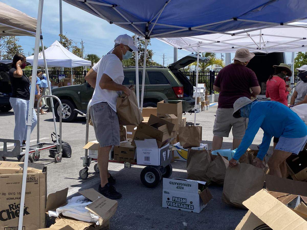 Volunteers at the Star of the Sea Outreach Mission distribute food to needy Florida Keys families at a park on Stock Island on May 7, 2020.
