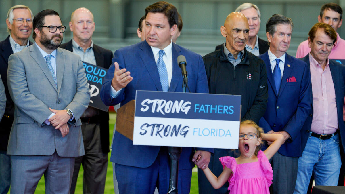 El gobernador Ron DeSantis, toma de la mano a su hija Madison en una conferencia de prensa el 11 de abril de 2022, en el AdventHealth Training Center en Tampa, Florida.