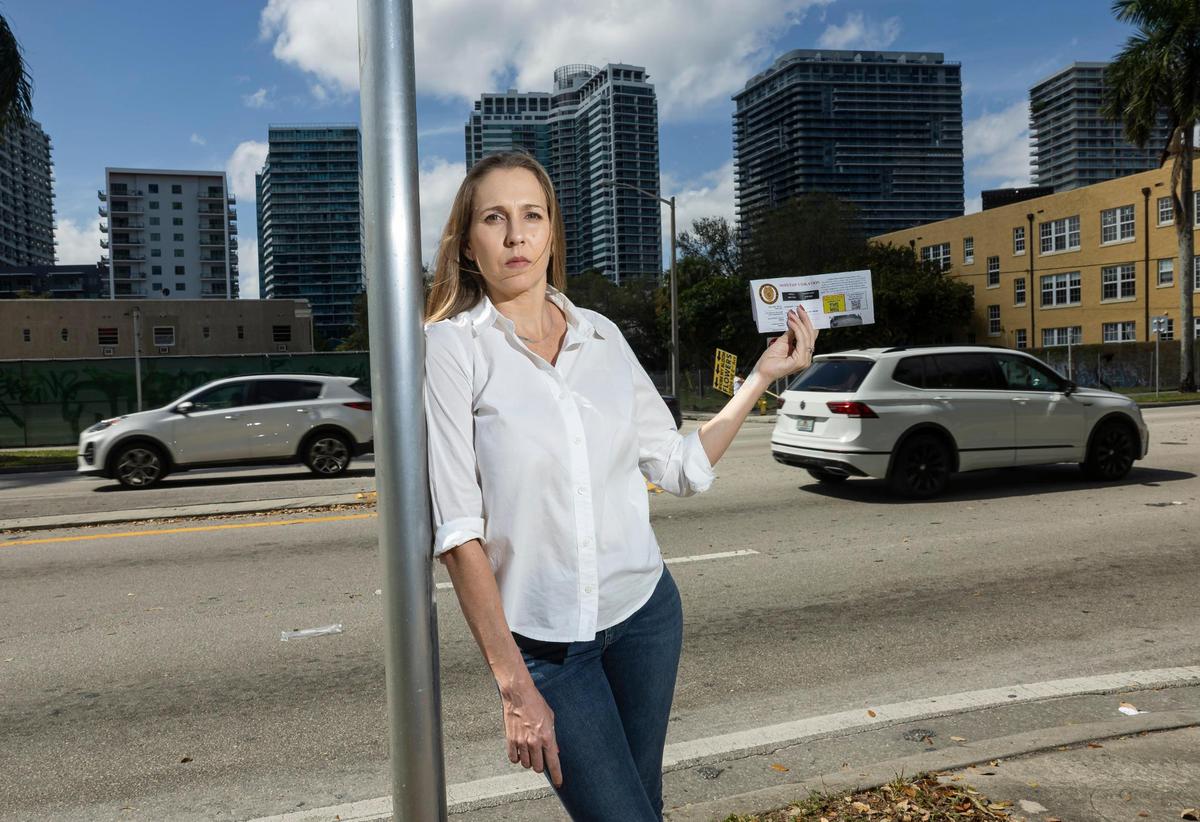 Jennifer González sostiene su notificación de infracción de tránsito cerca de la calle donde fue multada el viernes 21 de febrero de 2025 en Miami, Florida. González recibió una multa de $225 de la Policía de Miami-Dade.