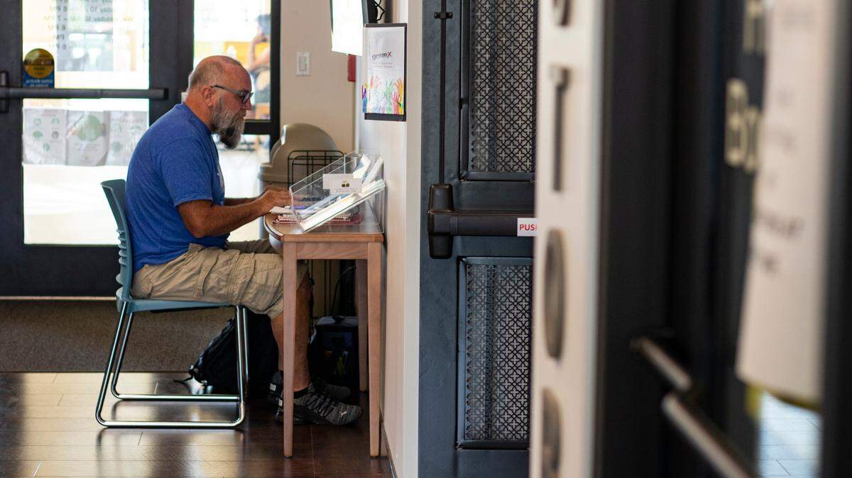 Mark Adkins, 63, Nationwide Financial CPA in compliance and ethics, works at a welcome desk that holds pamphlets at the Punta Gorda Charlotte Library on Tuesday, Oct. 11, 2022.