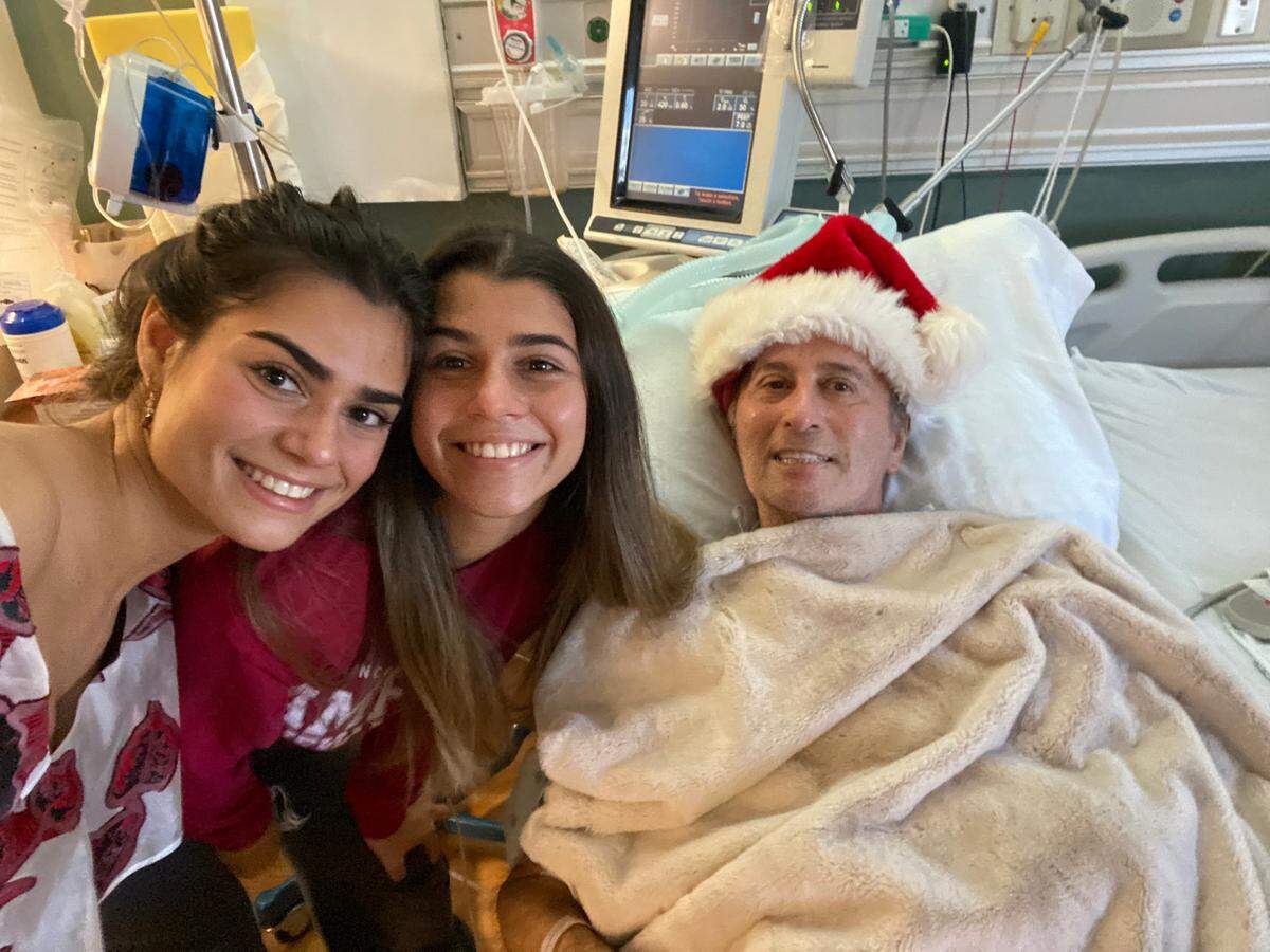 Nino Pernetti, propietario del Caffe Abbracci, en la foto con sus hijas Tatiana (izquierda) y Katerina, lleva más de un año en el hospital, recuperándose de los estragos del COVID-19.