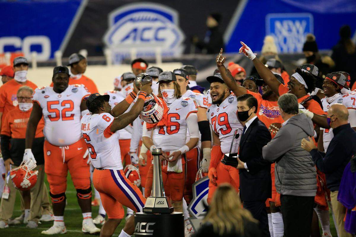 Clemson linebacker Mike Jones Jr. (6) holds up the trophy as he celebrates with teammates following their 34-10 victory over Notre Dame at the Atlantic Coast Conference championship NCAA college football game, Saturday, Dec. 19, 2020, in Charlotte, N.C.