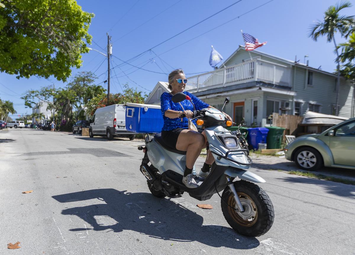 Dotti Clifford rides her moped near her home in Key West Florida, on Wednesday, April 17, 2019. Clifford’s home is roughly 100 square feet in size and has allowed her to live in an otherwise expensive neighborhood.