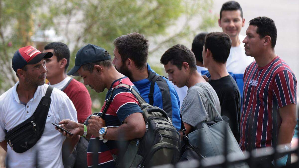 In San Antonio, Texas, migrants line up for refreshments at a Migrant Resource Center run by Catholic Charities in September 2022, after crossing the Mexico-U.S. border.