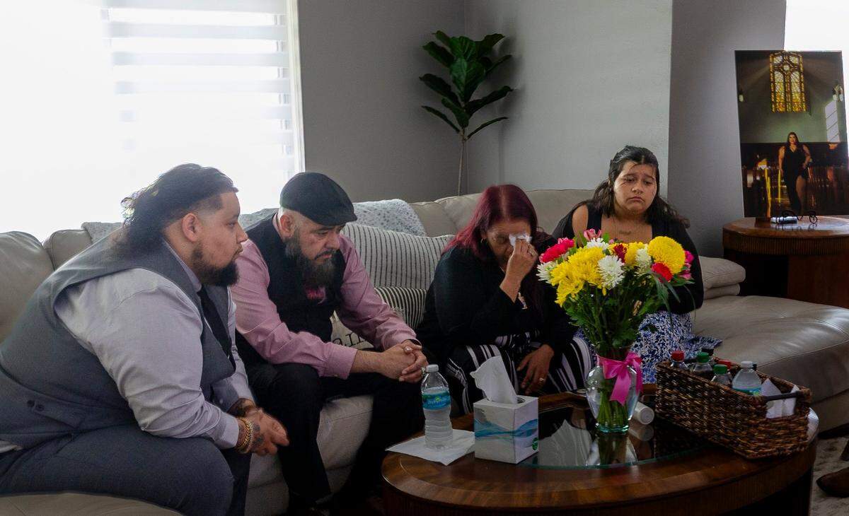 On Friday, June 20, 2025, in Homestead, Florida, (Left to right) Jose Valdes, 25, Bruce Figueroa, 52, Jocelyn Valdes, 17, Kristy Garcia, 46, and Jocelyn Valdes, 17, sit on the couch while they remember their daughter and sister, Evelyn Valdes, 28, whose life was tragically taken in a recent shooting on June 14, 2025, in Wynwood, Florida.