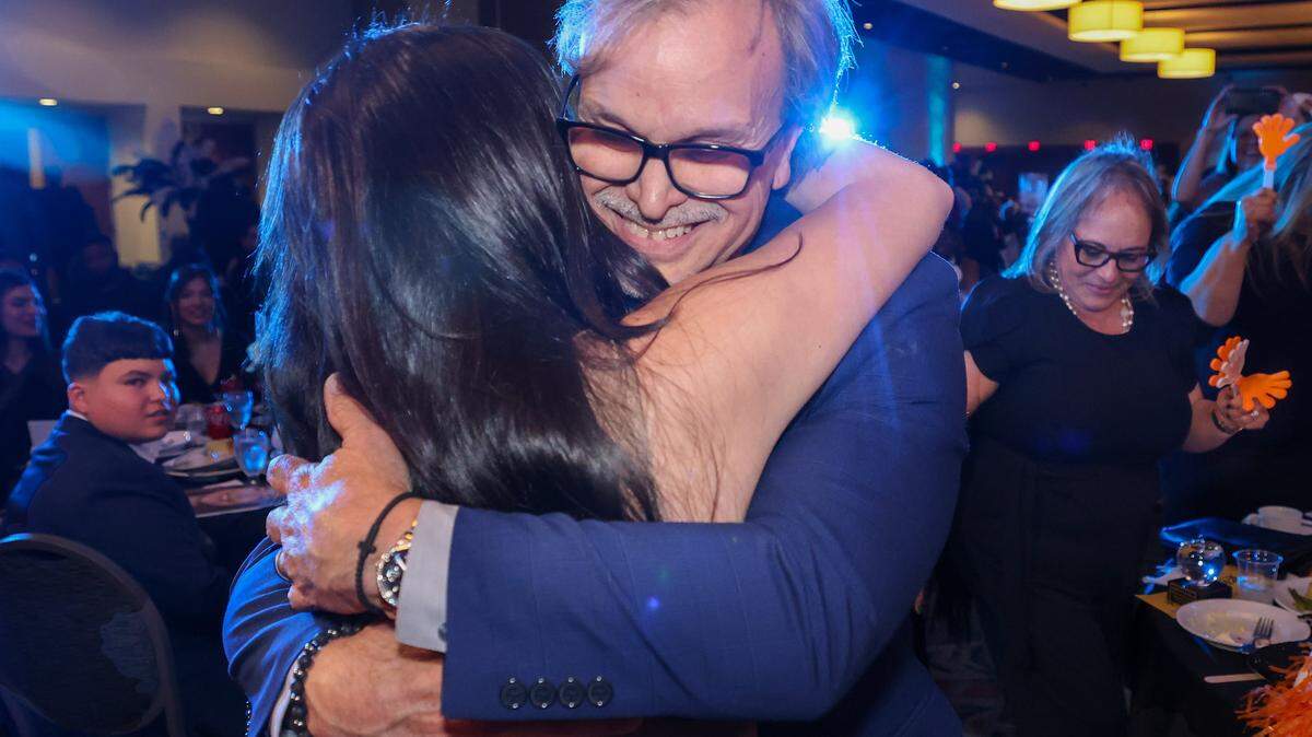 Roberto Rabelo, a social studies and civics teacher at South Miami Middle School, hugs his daughter Gabrielle after being named the 2027 Francisco R. Walker Teacher of the Year at the DoubleTree by Hilton Hotel Miami Airport & Convention Center and receiving a new Toyota Corolla, a cash prize and a gift basket on Wednesday, January 28, 2026, in Miami, Florida.