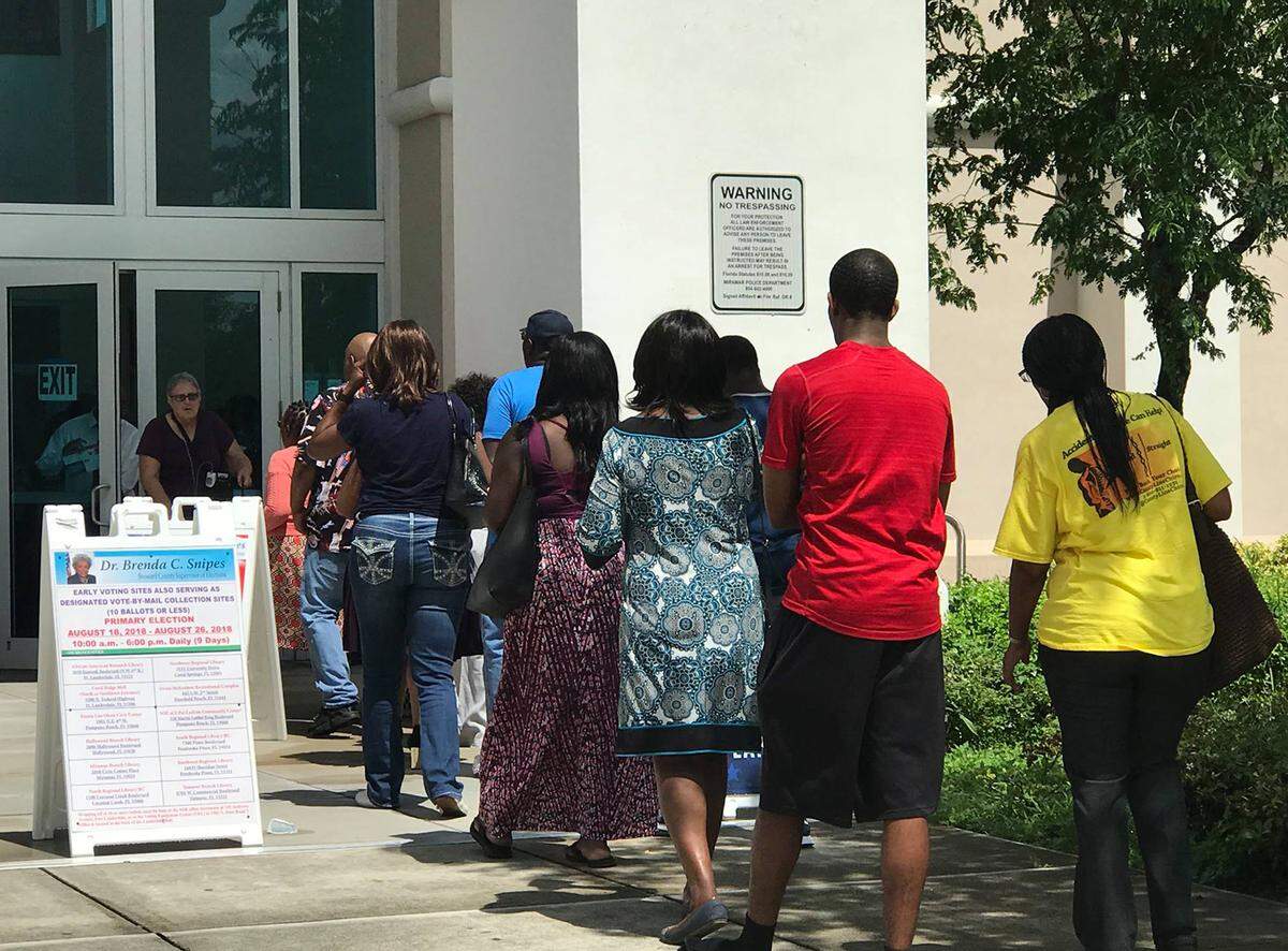People wait in line for early voting in the August primary at the Miramar library in Broward County.