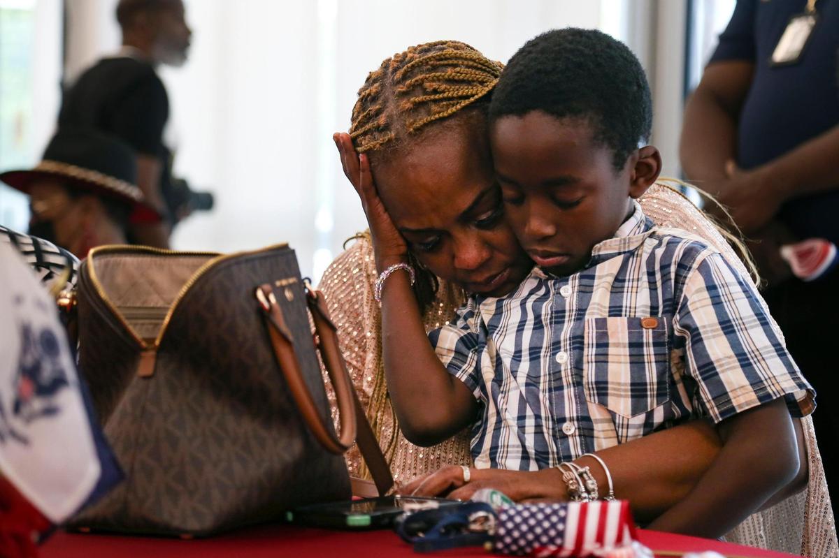 Cowanda Johnson, mother of fallen U.S soldier Sgt. La David T. Johnson, hugs her son Shavarius Brown, during a moment of prayer as the City of Miami Gardens hosted the Sgt. La David T. Johnson Memorial Day event.