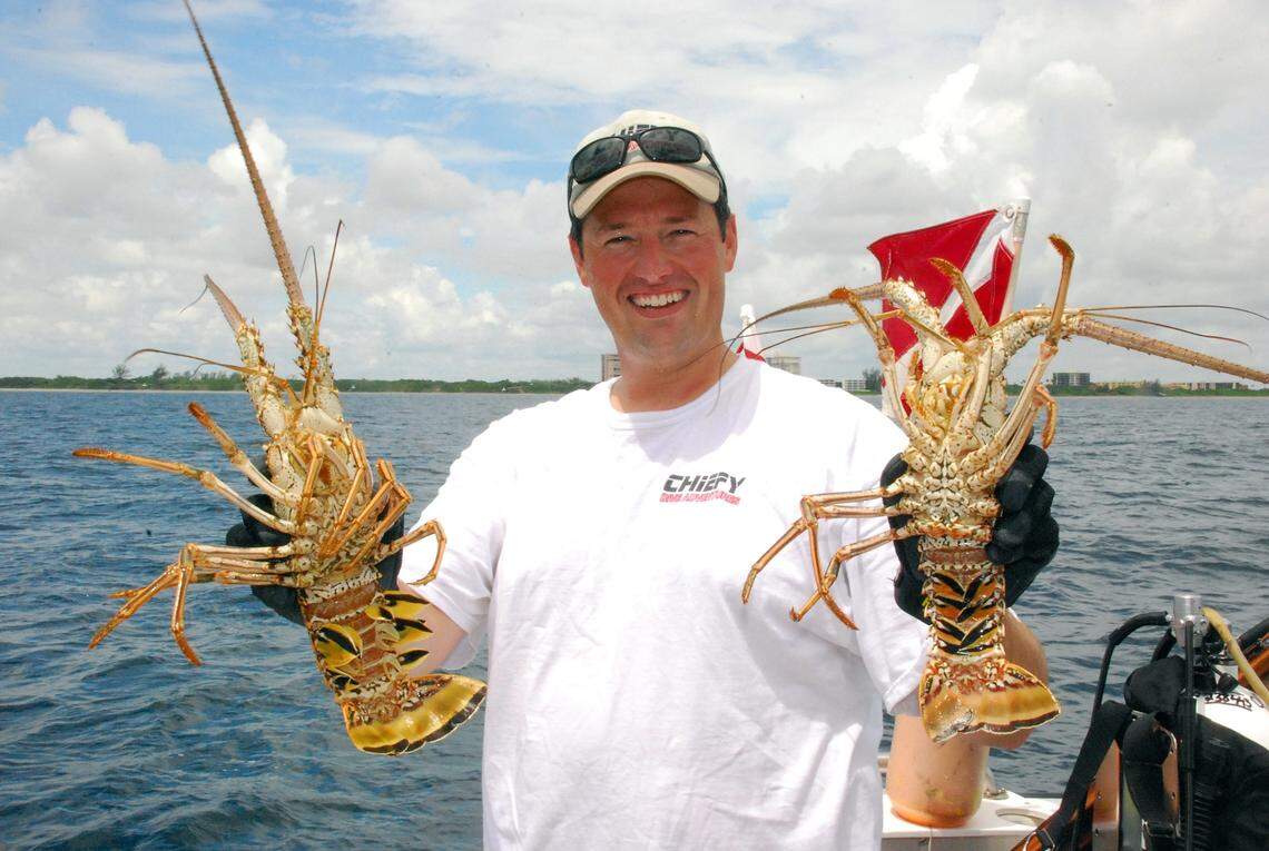 Braden Whitworth holding two lobsters he caught.
