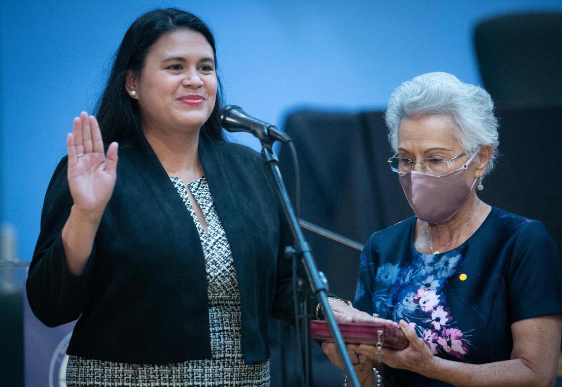 Lucía Baez-Geller levanta su mano derecha mientras presta juramento en la Junta Escolar de Miami-Dade el 17 de noviembre de 2020.