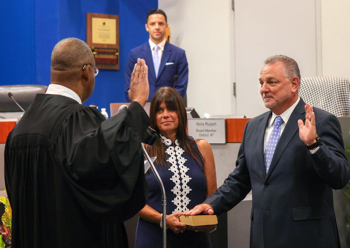 Broward Circuit Judge Elijah H. Williams left, swears in Peter B. Licata, right, with his wife Judy holding the Bible, as the superintendent of Broward County Public Schools at the Kathleen C. Wright Administration Center’s boardroom in Fort Lauderdale, Florida on Tuesday, July 18, 2023.