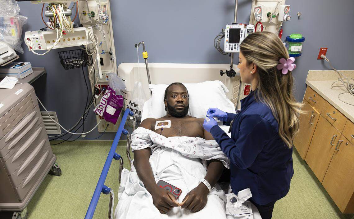 Chevon Byfield, 39, who suffers from heart failure and relies on a left ventricular assist device (LVAD), watches as nurse Denice Viamonte prepares to flush his central line ahead of a procedure at Memorial Regional Hospital on Tuesday, Feb. 3, 2026, in Hollywood, Fla.