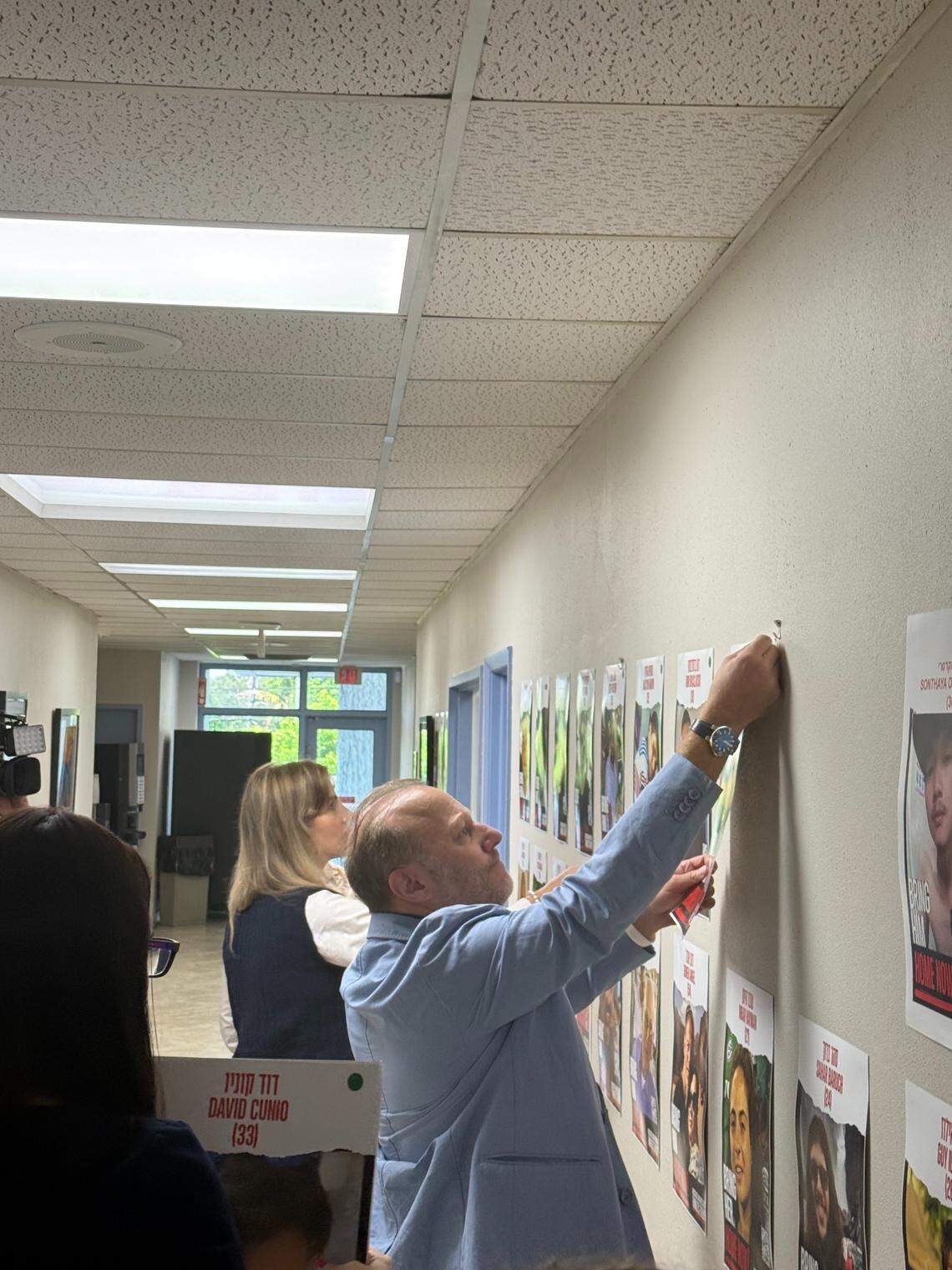 Scott Kaufman, president and CEO of the Greater Miami Jewish Federation, removes photos of hostages who were released to Israeli families on Monday as part of a ceasefire after two years of war between Israel and Hamas.