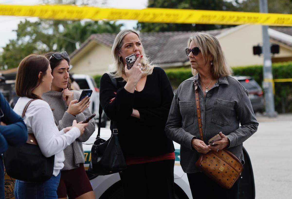 Family members wait outside Christopher Columbus High School on Southwest 87th Avenue as Miami-Dade Sheriff’s Office deputies respond to a report of an active shooter on Wednesday, Feb. 4, 2026, in Miami. Authorities said the call was a false threat and there was no shooter at the school, which went on lockdown as a precaution. 