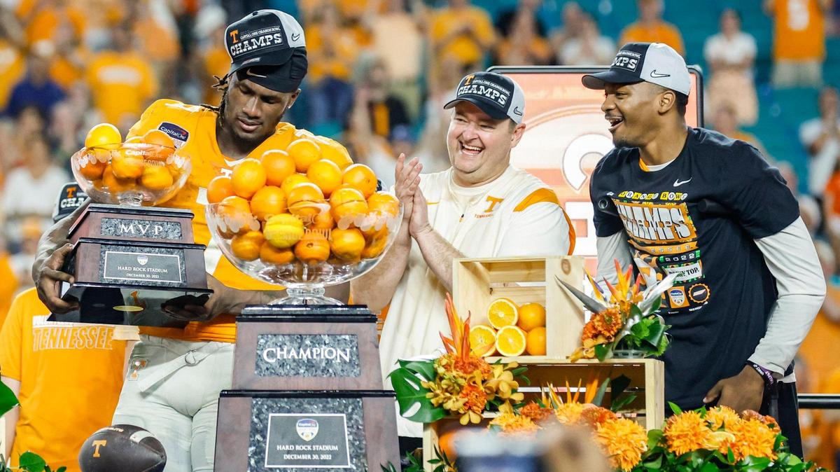 Tennessee Volunteers quarterback Joe Milton III (7) picks up the MVP trophy as head coach Josh Heupel and quarterback Hendon Hooker (5) join him in the celebration after the Volunteers defeat Clemson Tigers in the 2022 Capital One Orange Bowl at Hard Rock Stadium in Miami Gardens, Florida on Saturday, December 31, 2022.