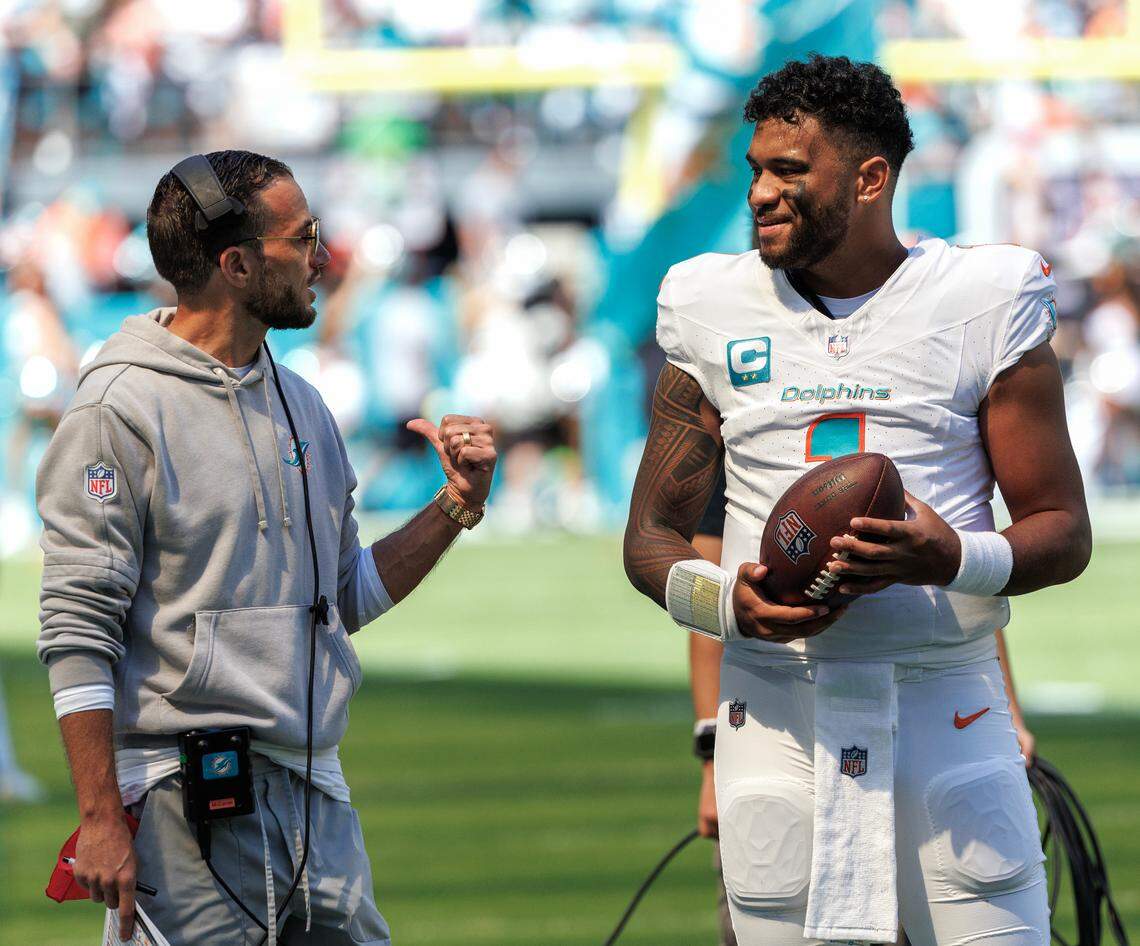 Miami Dolphins head coach Mike McDaniel talks with Dolphins quarterback Tua Tagovailoa (1) before the start of an NFL football game against the Carolina Panthers at Hard Rock Stadium on Sunday, Oct. 15, 2023 in Miami Gardens, Fl.