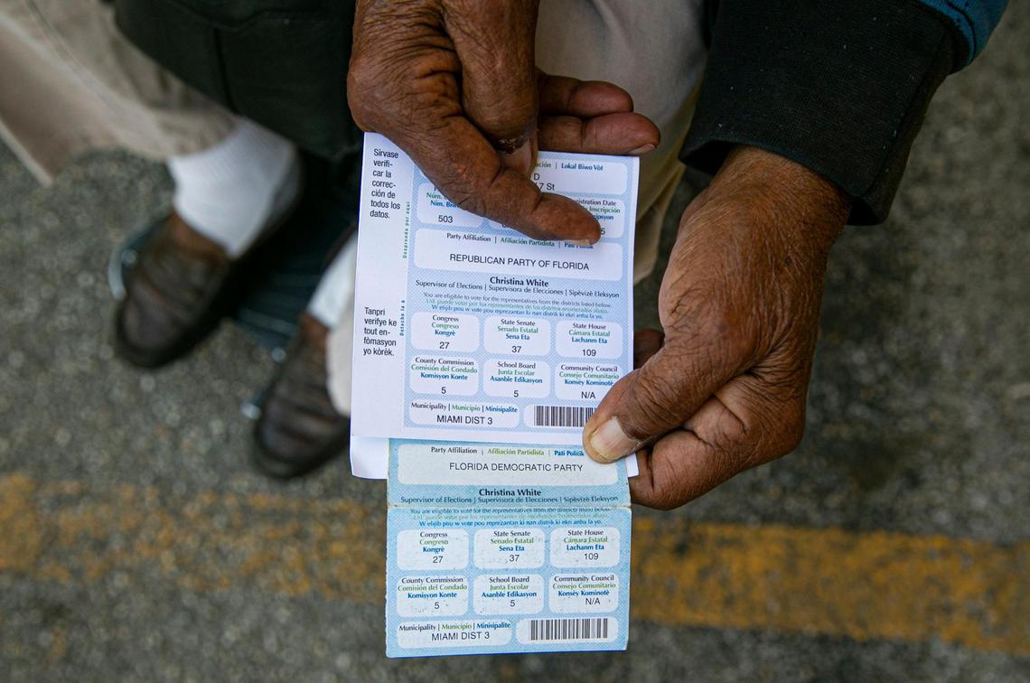 Juan Salazar, 77, holds his voter registration cards, outside of his apartment home in Little Havana, Florida on Saturday, February 5, 2022. Salazar explained his party affiliation was changed from Democrat to Republican without his permission.
