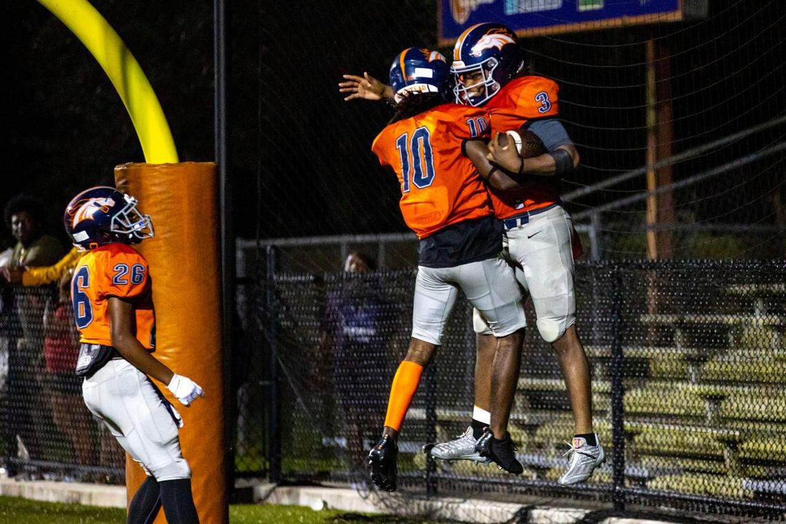 Homestead quarterback Joshua Townsend (3) reacts with teammate Jordan Rucker (10) after scoring a rushing touchdown against Miramar during the second half of a high school football game at Harris Field Park in Homestead, Florida, on Friday, November 25, 2022.