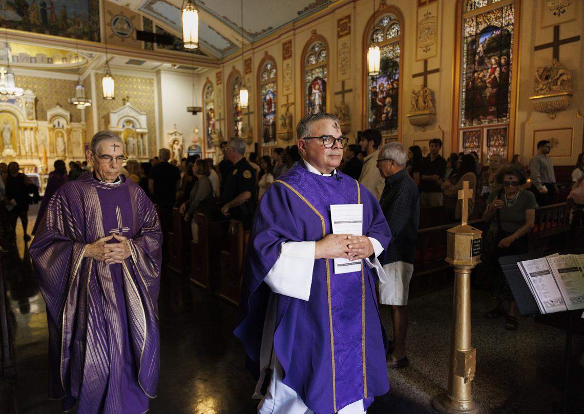 Fr. Orlando Portalatin, right, and Fr. Javier López lead the procession after Ash Wednesday mass on Wednesday, Feb. 18, 2026, at Gesu Catholic Church in downtown Miami. 