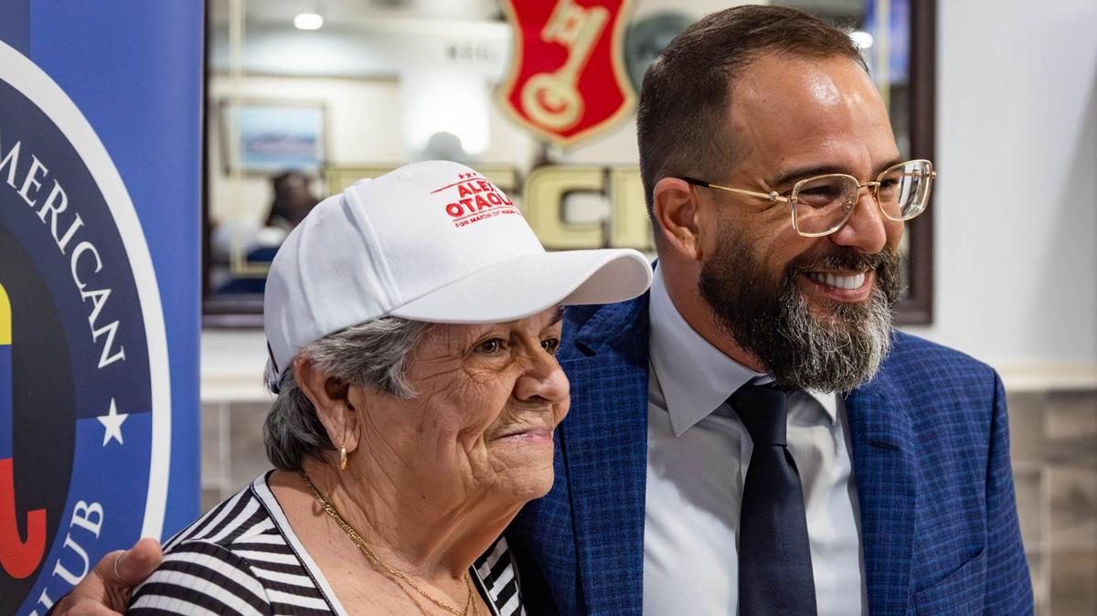 El candidato a la alcaldía del Condado Miami-Dade, Alexander Otaola, posa con su seguidora, María Luisa Rodríguez Portieles, en el evento de extensión comunitaria sobre temas venezolanos en el restaurante El Trópico, el miércoles 24 de julio de 2024 en Doral, Florida.