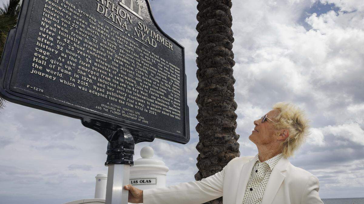 Diana Nyad poses with the street marker on Las Olas named after her on Thursday, Nov. 6, 2025, at Las Olas Oceanside Park in Fort Lauderdale, Fla. 
