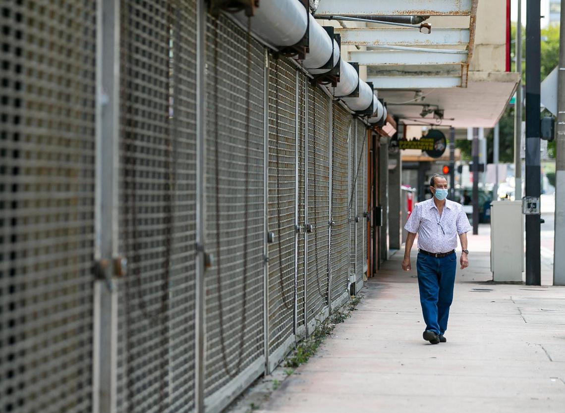 A man makes his way past shuttered storefronts owned by entrepreneur Moishe Mana on Southeast First Street in downtown Miami.