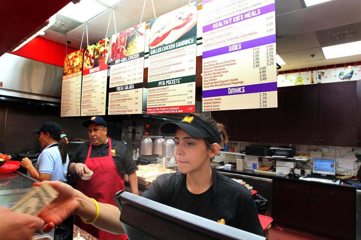 Lara Torres takes money from a customer at Chicken Kitchen in the food court at the Aventura Mall on June 24th, 2010.