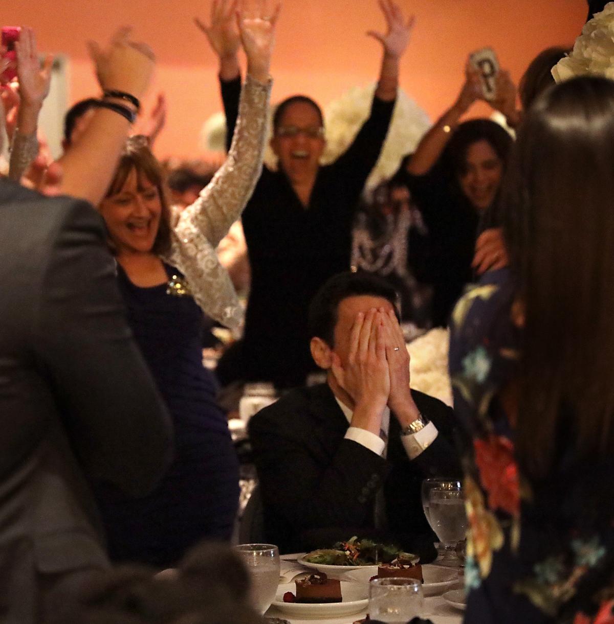 Oliver Diez of Palmetto Elementary, center, shields his eyes as colleagues, friends, and family celebrate his winning the 2020 Francisco R. Walker Miami-Dade County Teacher of the Year on Thursday, January 30, 2019 at the DoubleTree by Hilton Miami Airport Convention Center in Miami.