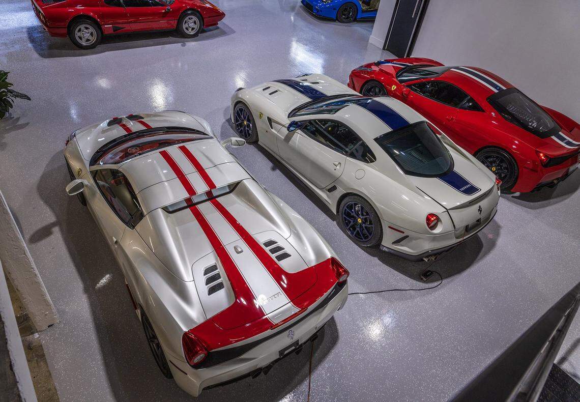 A white 2015 Ferrari 458 Speciale Aperta, a white 2011 Ferrari 599 GTO and a red 2014 Ferrari 458 Speciale, on display at the MCQ Markets luxury cars collection in Wynwood.