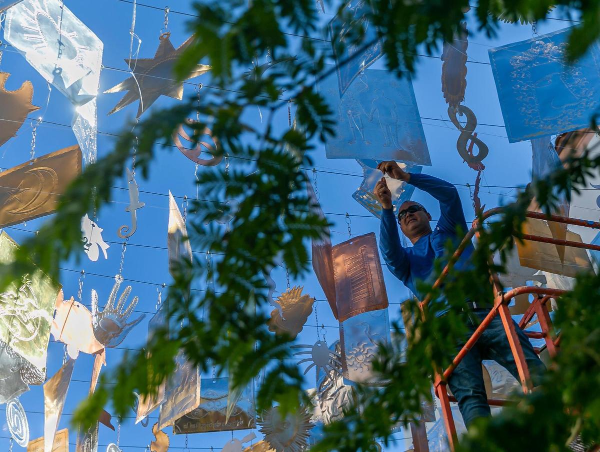 Un trabajador ajusta la instalación artística ¡Milagros! de Carlos Betancourt que se exhibe cerca de Española Way y Drexel Avenue en Miami Beach, Florida, el martes 30 de noviembre de 2021.
