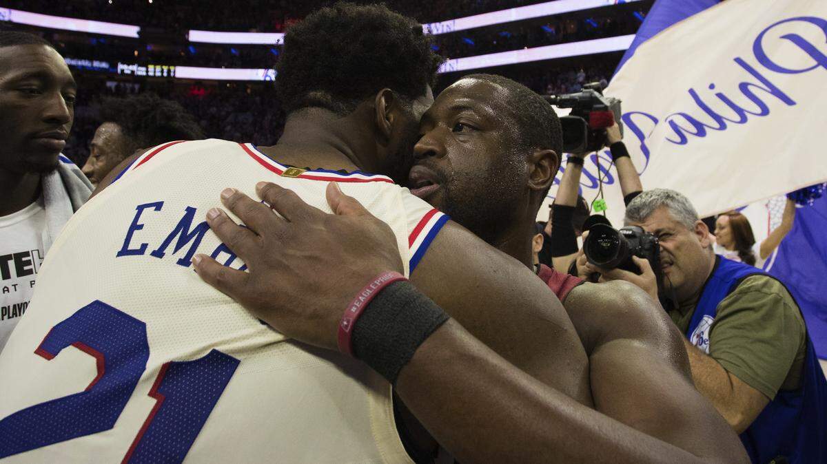 Miami Heat's Dwyane Wade, right, gives Philadelphia 76ers' Joel Embiid, left, of Cameroon, a hug after the second half in Game 5 of a first-round NBA basketball playoff series, Tuesday, April 24, 2018, in Philadelphia. The 76ers won 104-91. (AP Photo/Chris Szagola)