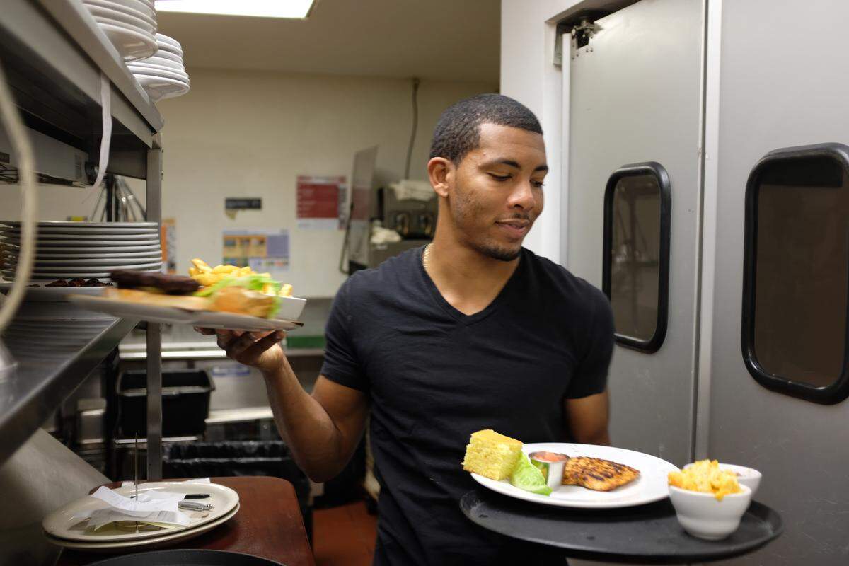 Karim Bryant Jr., home after graduating from Bethune-Cookman, helps run his family’s restaurant, Lil Greenhouse Grill.