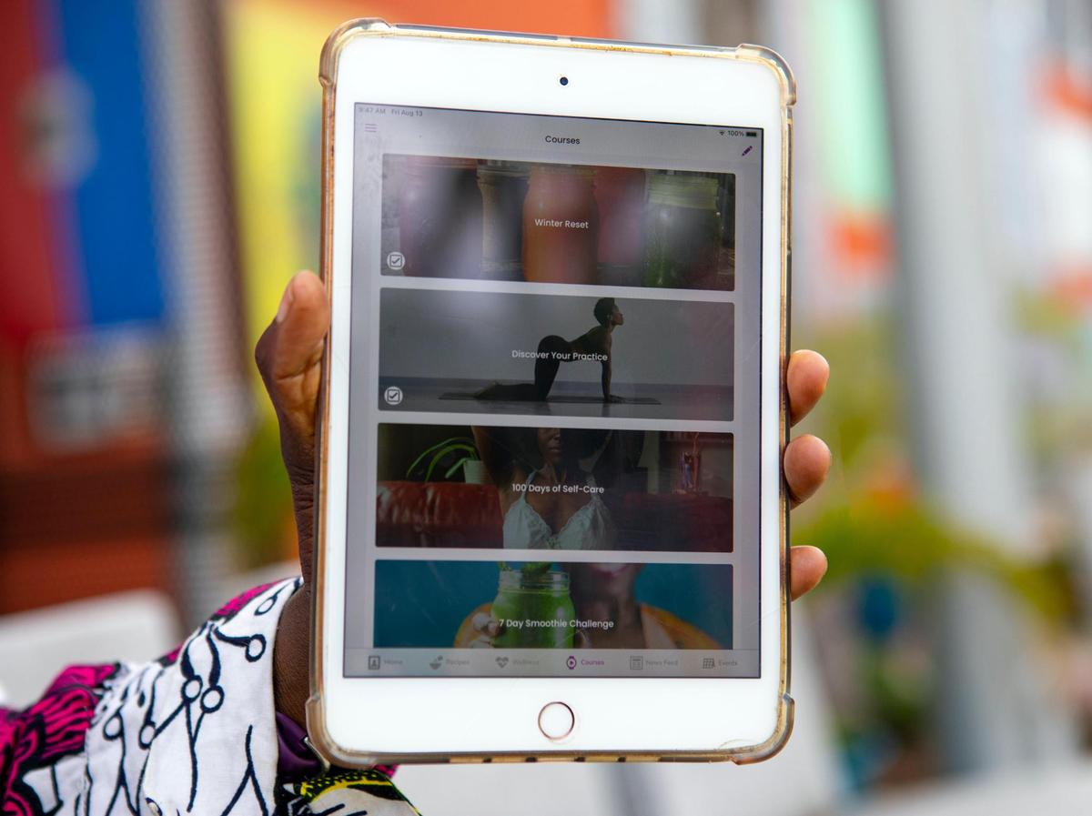 Entrepreneur Nzingah Oniwosan shows off her self-care application, 365Zing, which helps users become healthier through meal plans, yoga classes and therapy, at the Little Haiti Cultural Center in the Little Haiti neighborhood of Miami, Florida, on Friday, August 13, 2021. Oniwosan was one of thousands of Black Americans who started new businesses in 2020, a year that saw more Black entrepreneurial growth than at any time in the last 25 years, according to the Kauffman Foundation’s annual report.