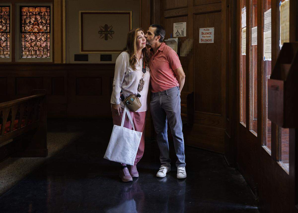 Jorge Ferragut, right, kisses Eileen Faxas on their way out of Ash Wednesday mass on Wednesday, Feb. 18, 2026, at Gesu Catholic Church in downtown Miami.  